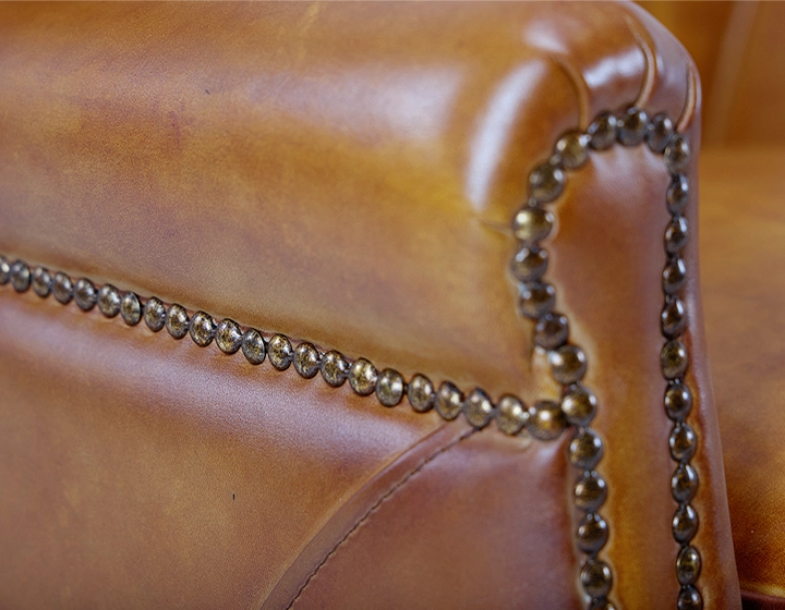 Fauteuil club cuir cognac accoudoirs cloutés