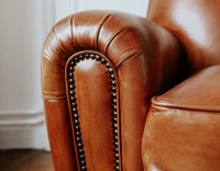 Fauteuil club cuir marron clair accoudoirs cloutés