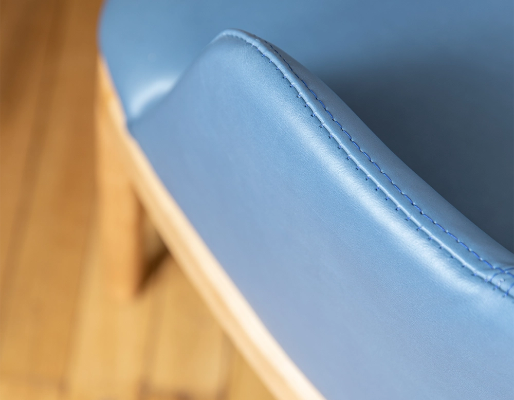 Silla de diseño con reposabrazos madera en tinte natural y piel azul tormenta
