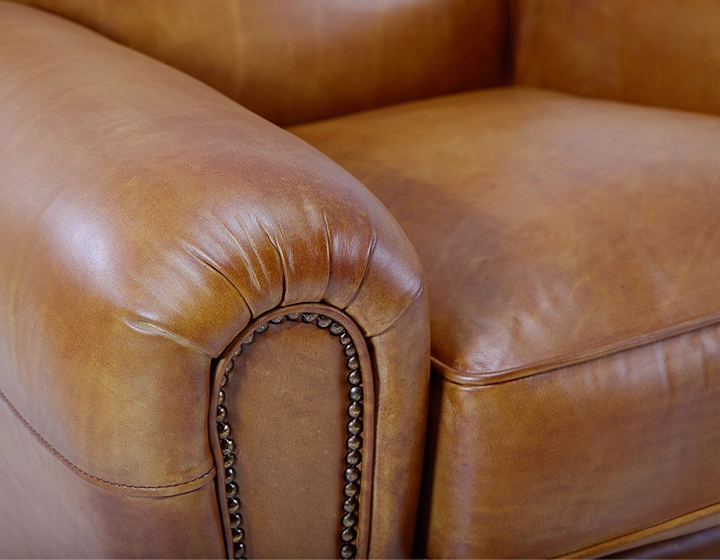 Fauteuil club cuir cognac accoudoirs cloutés