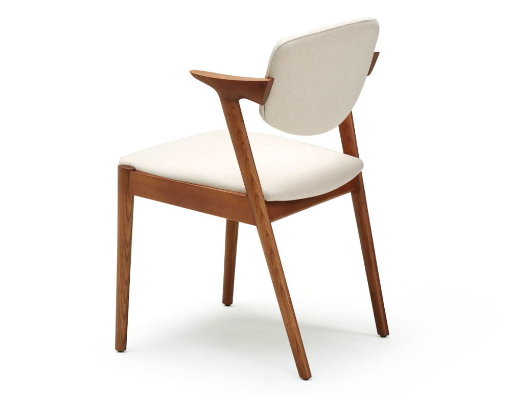 Scandinavian chair cherry wood stain with off-white fabric seat.